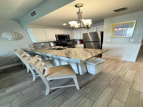 a kitchen with a marble counter top and chairs at Vacation in Comfort and luxury - 1 BR Direct Oceanfront - Wyndham Ocean Walk Resort 1607 in Daytona Beach