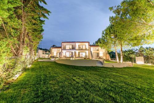 a large house in the middle of a yard at Pelagus Luxury Villas in Polykhrono