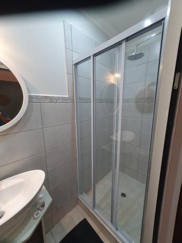 a bathroom with a glass shower and a sink at Willow's Corner-Just like home! in Durban