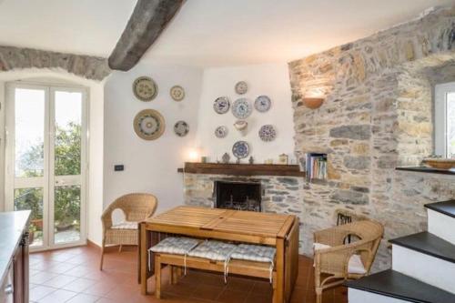 un salon avec une table et un mur en pierre dans l'établissement Rustico tra gli Ulivi, à Rapallo
