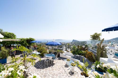 a patio with tables and umbrellas on a roof at Relais Bijoux Ischia in Ischia
