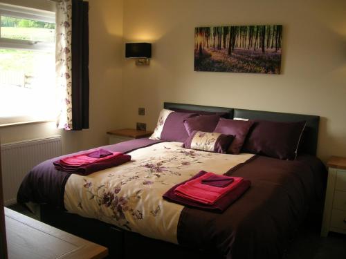 Un dormitorio con una cama con dos toallas encima. en Woodland Lodge Hot Tub Sleeps 6, en Hundred House