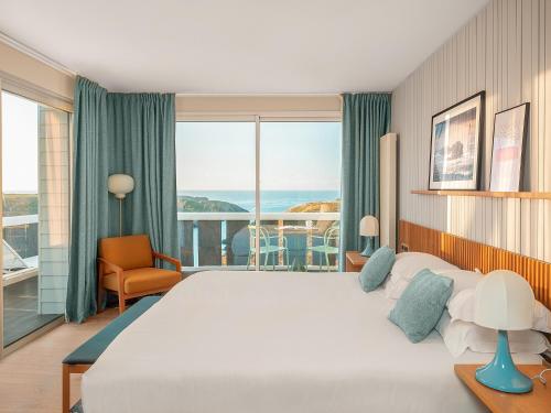 une chambre avec un grand lit et un balcon dans l'établissement Castel Clara Thalasso & Spa, à Bangor