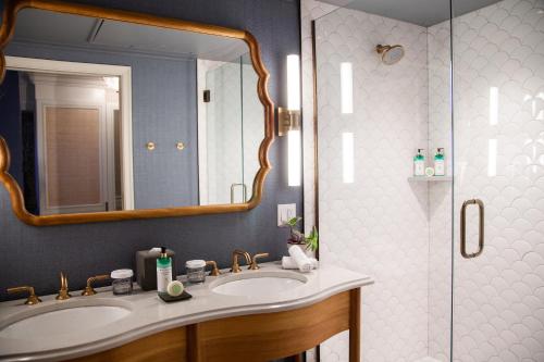a bathroom with a sink and a shower with a mirror at Delamar Mystic in Mystic