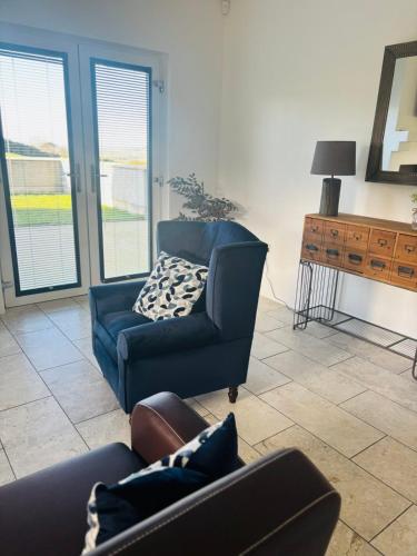 a living room with a couch and a chair at Andy's Cottages at the Well in Hilltown