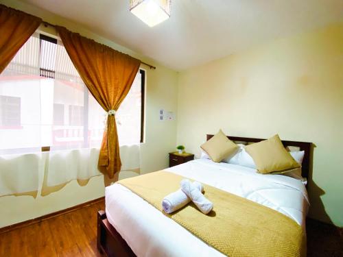 a bedroom with a bed with a stuffed animal on it at Habitaciónes Matrimoniales en Baños de Agua Santa con baño privado in Baños