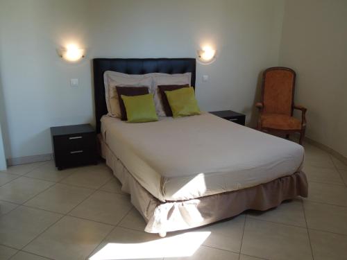 - une chambre avec un lit doté d'oreillers jaunes et d'une chaise dans l'établissement Appartement vue sur mer, à Santa-Maria-di-Lota