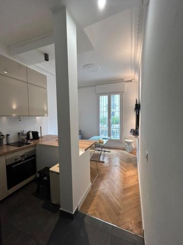 une cuisine avec des armoires blanches et un plancher en bois dans l'établissement Chic Flat Near the Beach, à Nice