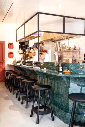 a bar with a row of stools in a kitchen at Grand Pigalle Experimental in Paris