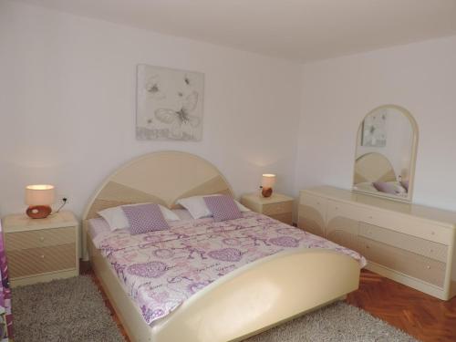 a bedroom with a bed and two dressers and a mirror at Holiday Home Voloder in Tarabnik