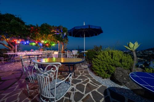 a patio with tables and chairs and an umbrella at Relais Bijoux Ischia in Ischia