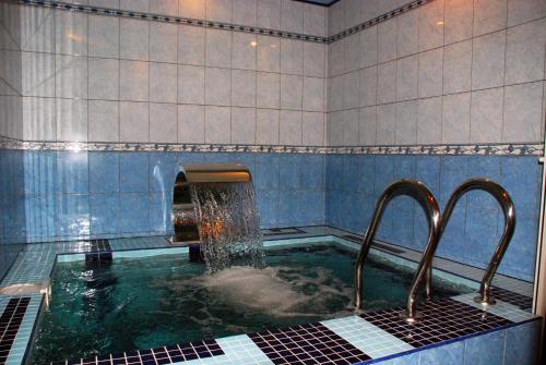 a bath tub with two faucets in a bathroom at Argo in Lviv