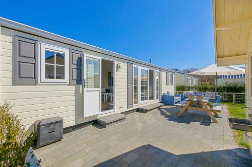 a large trailer with a picnic table and a picnic table at Chalet Luttikduin Nr 22 - Callantsoog aan Zee in Callantsoog
