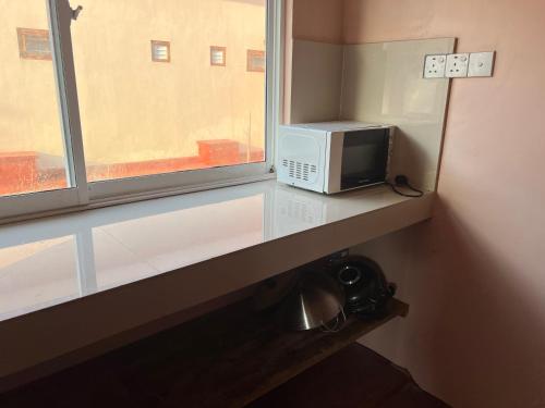 a microwave sitting on a counter next to a window at Palm Path Resort in Jaffna