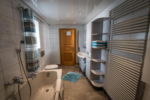a bathroom with a tub and a toilet and a sink at Ferienbauernhof Rosenberger in Hauzenberg
