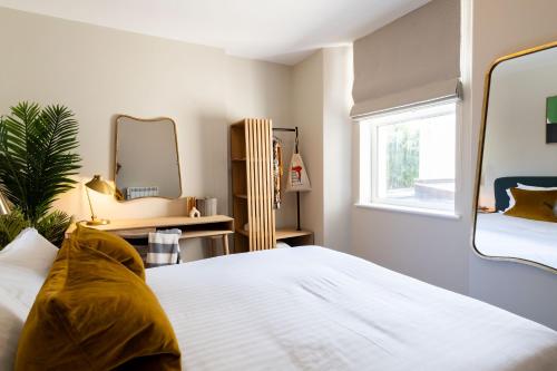 a bedroom with a large white bed and a mirror at Wellington Place I Your Apartment in Bristol