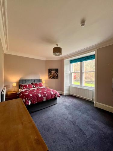 a bedroom with a red bed and a window at The Farmhouse Snug in Spean Bridge