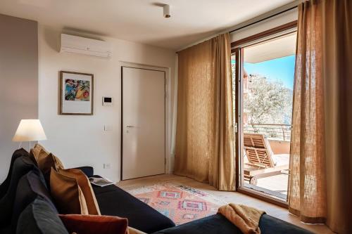 un salon avec un canapé et une grande fenêtre dans l'établissement Belsit - by MyHomeInComo, à Menaggio