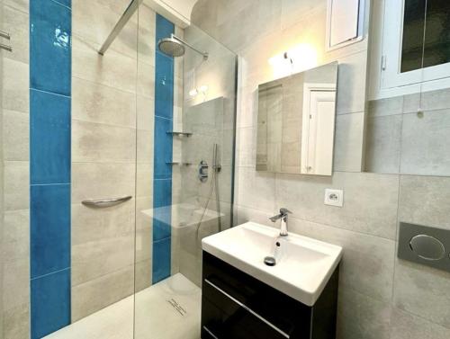 une salle de bain avec un lavabo et une douche en verre dans l'établissement Charming apartment steps away from La Croisette and Palais de Festival, à Cannes