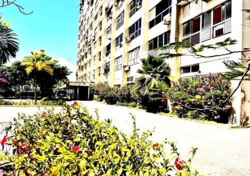 a building with flowers and plants in front of it at SeafrontApartment-Sleeps4-Pool-Parking-Garden in Porlamar
