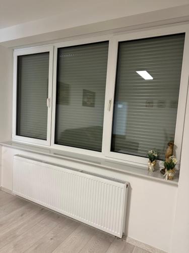 a living room with three windows with blinds at KOMFORT FerienWohnung NeuBau Merzig in Merzig