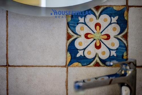 a bathroom tile with a flower on the wall at Villa Zuzana in Calabernardo