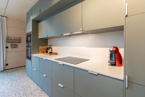 a kitchen with blue cabinets and a red appliance at Nature'Hayette in Tenneville
