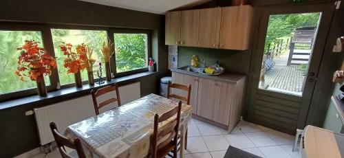 a kitchen with a table and some windows and a table and chairs at Spacious house in Montignies-sur-Roc with garden in Montignies-sur-Roc