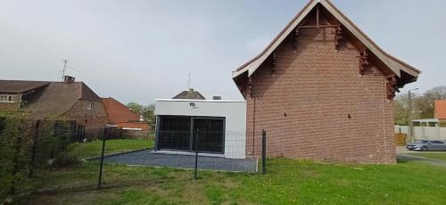 a building with a large door on the side of it at Charming Chalet in Roisin, 400 m² with Terrace in Meaurain