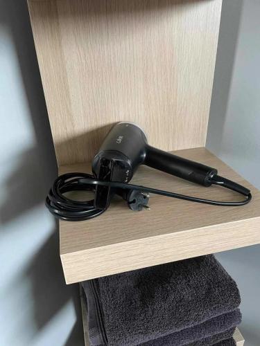 a black game controller sitting on top of a shelf at Charming Chalet in Roisin, 400 m² with Terrace in Meaurain