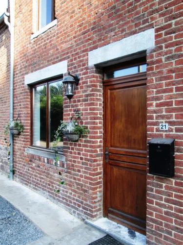 a brick building with a wooden door and a window at Spacious house in Montignies-sur-Roc with garden in Montignies-sur-Roc