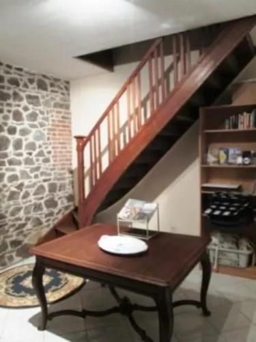 a wooden table in a living room with a staircase at Spacious house in Montignies-sur-Roc with garden in Montignies-sur-Roc
