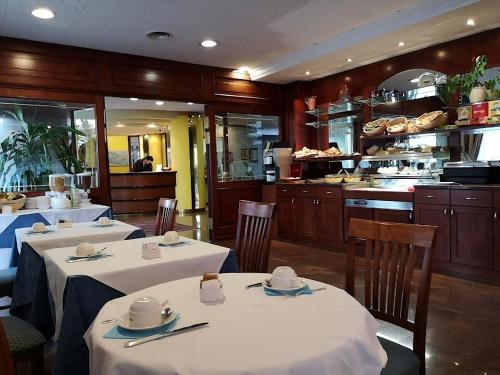 a restaurant with two tables with white tablecloths at Hotel President Venezia in Mestre