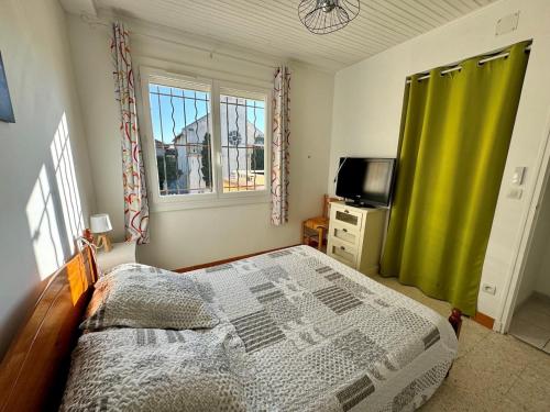 une chambre avec un lit et une télévision dans l'établissement Appartement - Le Grau d'Agde, au Grau-dʼAgde