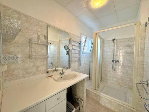 une salle de bain avec un lavabo et une douche dans l'établissement Appartement - Le Grau d'Agde, au Grau-dʼAgde