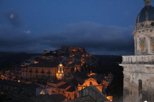 a view of a city at night with a clock tower at B&B Belvedere All'Idria in Ragusa