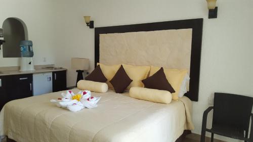 a bedroom with a large bed with two flowers on it at Hotel Club Akumal Caribe in Akumal