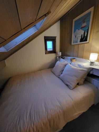 une chambre avec un grand lit dans une pièce dans l'établissement Duplex les Myrtilles LES CARROZ centre station, aux Carroz d'Arâches