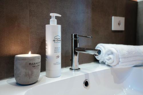 - un lavabo avec une bouteille de shampoing et une bougie dans l'établissement Belsit - by MyHomeInComo, à Menaggio