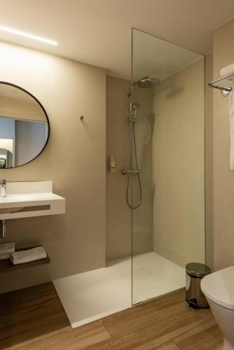 a bathroom with a shower and a toilet and a sink at Silken Puerta de Irati in Ochagavía