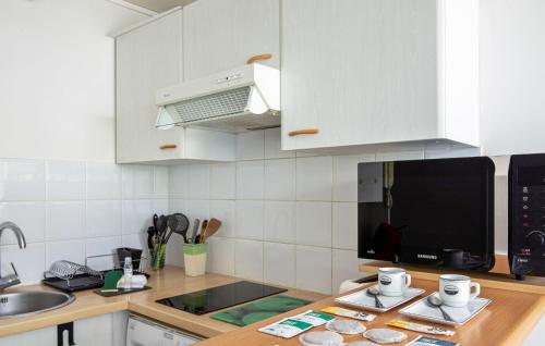 une cuisine avec des armoires blanches et un comptoir dans l'établissement Cozy Apartment In La Rochelle With Wifi, à La Rochelle