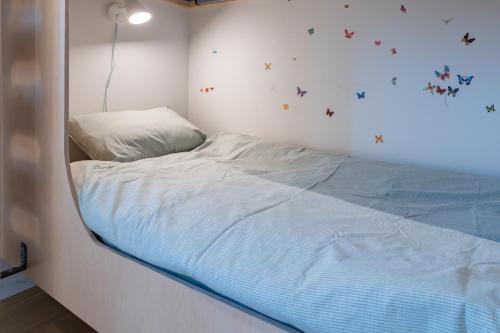 a bedroom with a bed with butterflies on the wall at Nature'Hayette in Tenneville
