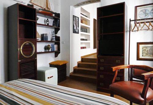 a bedroom with a bed and a chair and a television at Tosti 79 in Formia