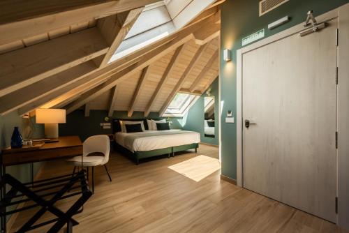 a bedroom with a bed and a desk and a door at Silken Puerta de Irati in Ochagavía