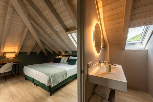a bedroom with a bed and a sink and a mirror at Silken Puerta de Irati in Ochagavía