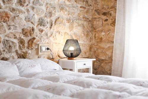 a bedroom with two beds and a table with a lamp at Casa Rural Sant Roc in Murla
