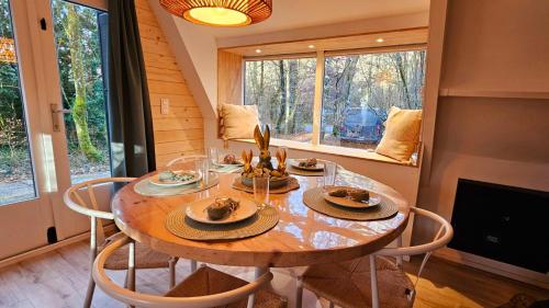 a dining room with a wooden table and chairs at De Bosdriehoek III in Durbuy