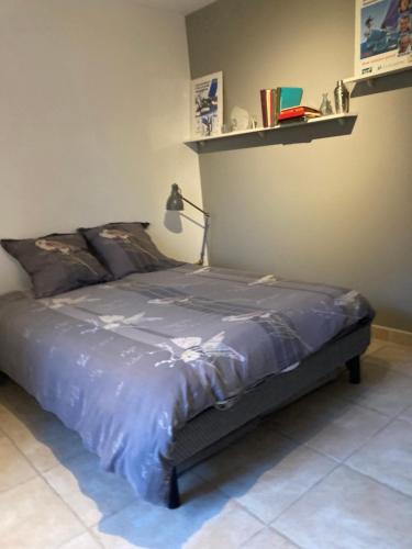 - un lit dans une chambre avec une étagère sur le mur dans l'établissement Villa entre Mer et Cévennes, à Villetelle