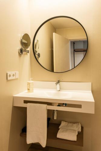 a bathroom with a white sink and a mirror at Silken Puerta de Irati in Ochagavía