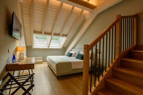 a bedroom with a bed and a staircase in a house at Silken Puerta de Irati in Ochagavía